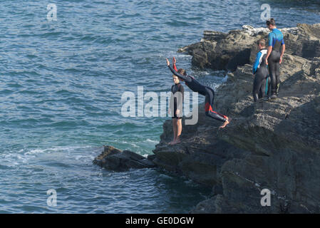 Eine Gruppe von Teenagern dieser Art der Kennzeichnung von den Klippen auf der Landzunge in Newquay, Cornwall. Stockfoto