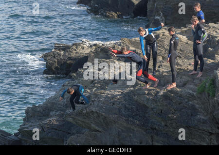 Eine Gruppe von Teenagern dieser Art der Kennzeichnung von den Klippen auf der Landzunge in Newquay, Cornwall. Stockfoto