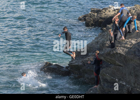 Eine Gruppe von Teenagern dieser Art der Kennzeichnung von den Klippen auf der Landzunge in Newquay, Cornwall Stockfoto