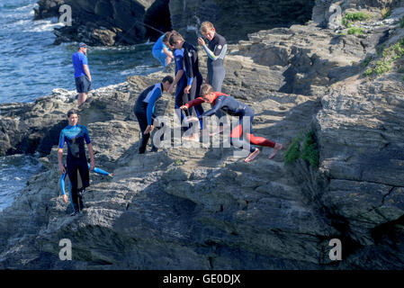 Eine Gruppe von Teenagern dieser Art der Kennzeichnung von den Klippen auf der Landzunge in Newquay, Cornwall. Stockfoto