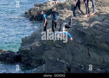 Eine Gruppe von Teenagern dieser Art der Kennzeichnung von den Klippen auf der Landzunge in Newquay, Cornwall. Stockfoto