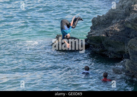 Eine Gruppe von Teenagern dieser Art der Kennzeichnung von den Klippen auf der Landzunge in Newquay, Cornwall. Stockfoto