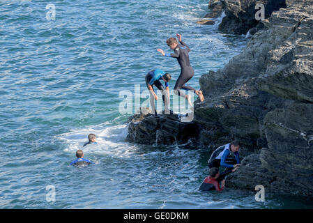 Eine Gruppe von Teenagern dieser Art der Kennzeichnung von den Klippen auf der Landzunge in Newquay, Cornwall. Stockfoto