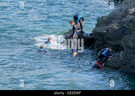 Eine Gruppe von Teenagern dieser Art der Kennzeichnung von den Klippen auf der Landzunge in Newquay, Cornwall. Stockfoto