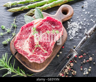 Rib-Eye Steak mit Gewürzen auf dem Graphit-Brett. Stockfoto
