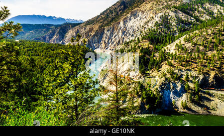 Lange Containerzüge nach dem Thompson River entlang steiler Klippen und durch Tunnel in den Fraser Canyon in British Columbia, Kanada Stockfoto