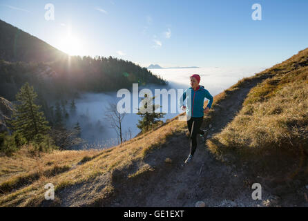 Trailrunning-Frau in den Bergen über den Wolken, Salzburg, Österreich Stockfoto