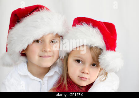 Porträt eines jungen und Mädchen tragen Weihnachten Santa Hüte Stockfoto