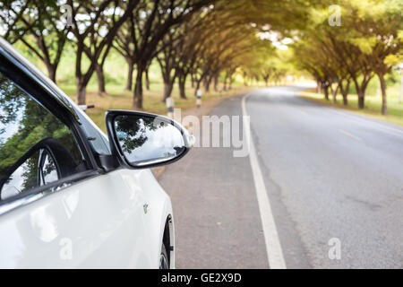 Nahaufnahme Sideview Spiegel weiße Autos neben der Straße. Stockfoto