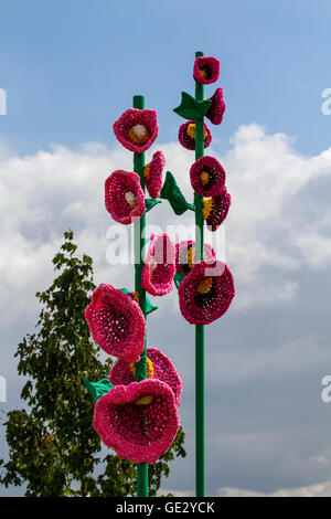 Gestrickte Blumentopf-Mohnkunst, gestrickte Blumenmuster, Kunstwerke von großen Blumen mit übergroßen Stielen und Blütenblättern, farbenfrohe, große, gestrickte Mohnhäkchen, gehäkelte Mohnblumen am Gedenktag, die nach dem Himmel greifen. Großformatige Kunstwerke, Häkelblumen-Design Rote Erinnerung Mohnblumen & Mohnblumen auf der Tatton Park Flower Show, Großbritannien Stockfoto