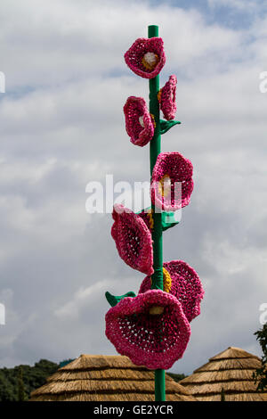 Gestrickte Blumentopf-Mohnkunst, gestrickte Blumenmuster, Kunstwerke von großen Blumen mit übergroßen Stielen und Blütenblättern, farbenfrohe, große, gestrickte Mohnhäkchen, gehäkelte Mohnblumen am Gedenktag, die nach dem Himmel greifen. Großformatige Kunstwerke, Häkelblumen-Design Rote Erinnerung Mohnblumen & Mohnblumen auf der Tatton Park Flower Show, Großbritannien Stockfoto