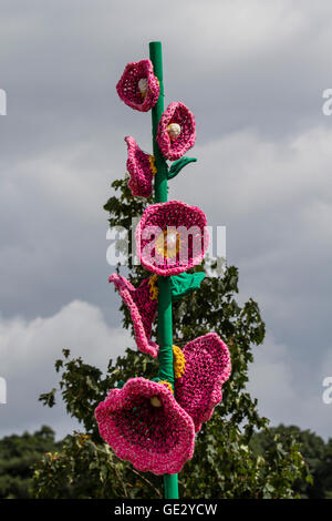 Gestrickte Blumentopf-Mohnkunst, gestrickte Blumenmuster, Kunstwerke von großen Blumen mit übergroßen Stielen und Blütenblättern, farbenfrohe, große, gestrickte Mohnhäkchen, gehäkelte Mohnblumen am Gedenktag, die nach dem Himmel greifen. Großformatige Kunstwerke, Häkelblumen-Design Rote Erinnerung Mohnblumen & Mohnblumen auf der Tatton Park Flower Show, Großbritannien Stockfoto