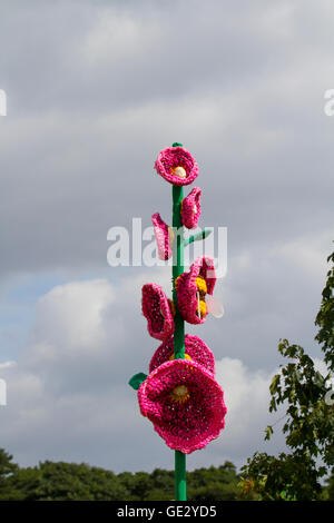 Gestrickte Blumentopf-Mohnkunst, gestrickte Blumenmuster, Kunstwerke von großen Blumen mit übergroßen Stielen und Blütenblättern, farbenfrohe, große, gestrickte Mohnhäkchen, gehäkelte Mohnblumen am Gedenktag, die nach dem Himmel greifen. Großformatige Kunstwerke, Häkelblumen-Design Rote Erinnerung Mohnblumen & Mohnblumen auf der Tatton Park Flower Show, Großbritannien Stockfoto