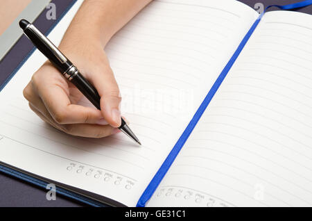 Write-Aktivität (eine Mädchen Hand hält einen Stift und schreiben auf ein Buch) Stockfoto