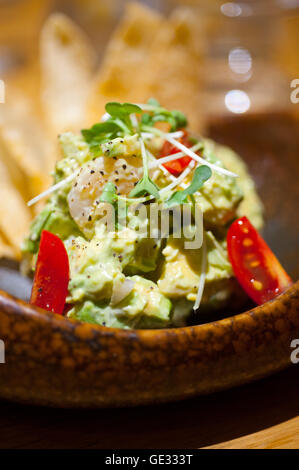 frische Avocado und Garnelen-Salat mit Nachos auf Seite Stockfoto
