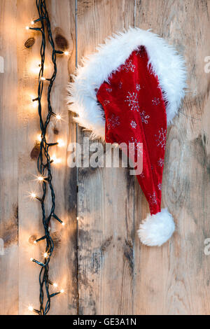 Weihnachtsmann-Mütze hing an einer Holzwand Stockfoto