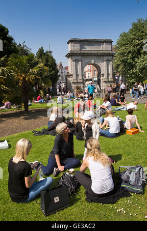 Irland, Dublin, St. Stephens Green, Menschen saßen auf Rasen in der Sonne von Dublin Fusiliers Arch Stockfoto