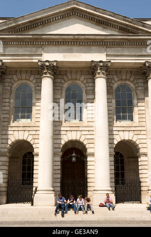 Irland, Dublin, Trinity College, Parliament Square, Besucher saßen auf Kapelle Schritte Stockfoto