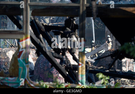 Berlin-Britz, Deutschland. 22. Juli 2016. Feuerwehrleute während der abschließenden Löschmittel arbeiten auf dem Gelände der ehemaligen öffentlichen Freizeit Schwimmbad "Blub" in Berlin-Britz, Deutschland, 22. Juli 2016. Bis zu 100 Feuerwehrleute mit sechs Lastwagen waren beschäftigt die Löscharbeiten in der Nacht. Die früher beliebten öffentlichen Freizeitbad "Blub" hat im Jahr 2005 geschlossen. Das Gebäude soll abgerissen werden. 450 neue Wohnungen sollen auf dem Gelände mit 35.000 Quadratmetern errichtet werden. Foto: RAINER JENSEN/Dpa/Alamy Live-Nachrichten Stockfoto