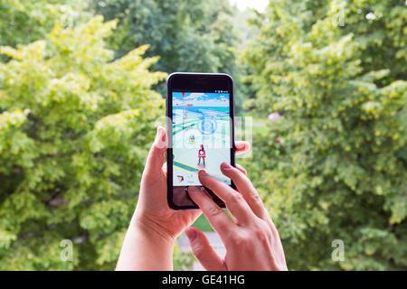 Apple iPhone6 Plus hielt in der einen Hand seinen Bildschirm mit Pokemon Go Anwendung zeigen. Stockfoto