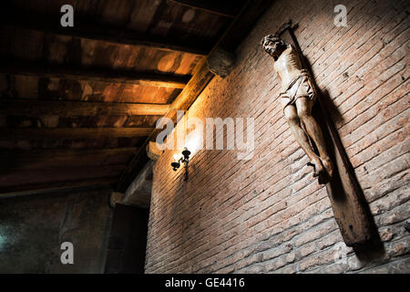 Jesus Christus am Kreuz ohne Armlehnen im alten Schloss in der Dämmerung Stockfoto