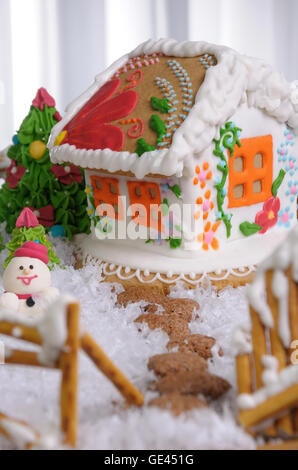 Lebkuchenhaus gemalt im Ethno-Stil unter den Bäumen und Schnee Stockfoto