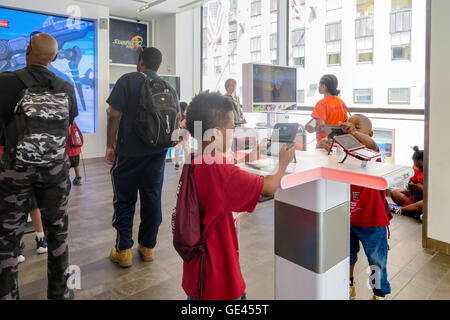 Jungen spielen mit Spiel-Konsole, Nintendo New York Store Interieur, Rockefeller Center, NYC, USA Stockfoto