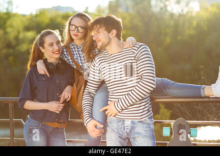 Freundschaft, Freizeit, Sommer, Technologie und Mensch Konzept - lächelnden Freunde, die Spaß im freien Stockfoto