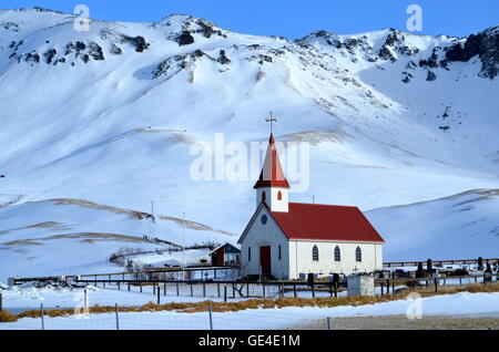 Reyniskirkja Kirche in der Nähe von Reynisfjara Strand in der Nähe von Vik, Island im Winter an einem sonnigen Tag mit Snowy Mountains im Hintergrund Stockfoto