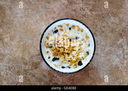 Schüssel mit frischem Müsli mit einer Mischung aus Weizen, Hafer und Kleie mit Trockenfrüchten und Nüssen über Stein Hintergrund, Exemplar, Ansicht von oben. Stockfoto