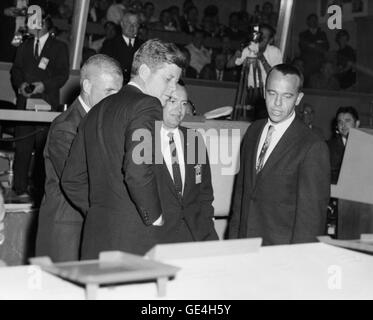 Präsident John F. Kennedy ist über den Betrieb von Quecksilber Control Center in Cape Canaveral unterrichtet nach dem Flug des Mercury-Atlas 6 (MA-6). Dies war Präsident Kennedys erster Besuch in Cape Canaveral. MA-6 Astronaut John H. Glenn, Jr. (teilweise verdeckt) pilotiert das Quecksilber "Friendship 7" Raumschiff in den Vereinigten Staaten erste menschliche Orbitalflug. In der Mitte (auf Glenns links) ist Christopher C. Kraft, Jr., MA-6 Flight Director und Chief of Flight Operations bei besetzt Spacecraft Center (MSC). Die MA-6 flog am 20. Februar 1962. Astronaut Alan B. Shepard, Jr. (rechts), p Stockfoto