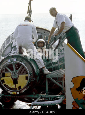 Astronaut Walter H. Schirra Jr. (rechts), Pilot, klettert aus seinem Raumschiff Gemini VI Befehl, wie er und Astronaut Thomas P. Stafford (nicht in der Ansicht) an Bord des Flugzeugträgers USS Wasp ankommen. Sie sind durch verschiedene McDonell Douglas Techniker unterstützt. Im westlichen Atlantik wasserte Gemini VI-Raumschiff erholen Bereich um 10:29 (EST) 16. Dezember 1965, nach einer erfolgreichen 25 Std. 52 Minuten-Mission im Weltraum.  Bild #: S65-61819 Datum: 16. Dezember 1965 Stockfoto