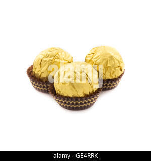 Süßen Schokokugeln mit Mandel eingehüllt in Goldfolie Papier auf weißem Hintergrund Stockfoto