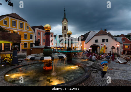 Zwettl: Hundertwasser Brunnen auf dem Hauptplatz in einem Stadtfest, im Hintergrund die Pfarrkirche, Österreich, Niederöster Stockfoto