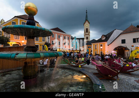 Zwettl: Hundertwasser Brunnen auf dem Hauptplatz in einem Stadtfest, im Hintergrund die Pfarrkirche, Österreich, Niederöster Stockfoto