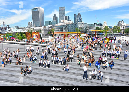 Southwark Büroangestellte unter heißen sonnigen Mittagspause mehr London Scoop am Flussufer Amphitheater mit City Of London Skyline über England UK Stockfoto