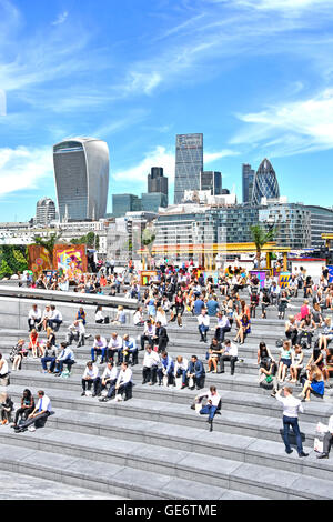 Southwark-Büroangestellte machen auf den Treppen des More London Scoop Amphitheatre City of London eine Pause zum sonnigen Mittagessen außerhalb von England UK Stockfoto