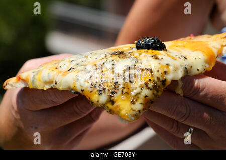 Jemand hält ein köstliches frisch gekochtes Stück Pizza vier Käse Stockfoto