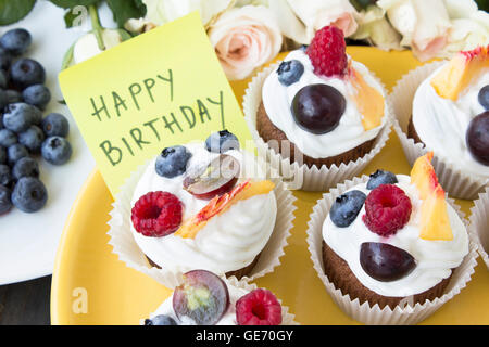 Erfrischende Frucht-Cupcakes mit 'Happy Birthday' Briefpapier. Stockfoto