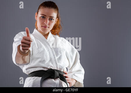 Frau trägt Karate Kimono mit Daumen nach oben Stockfoto