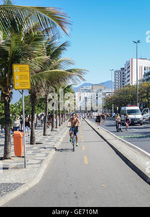 Aktive Bewohner und Touristen schlendern entlang in der Nähe von Posto 9 am Strand von Ipanema Stockfoto