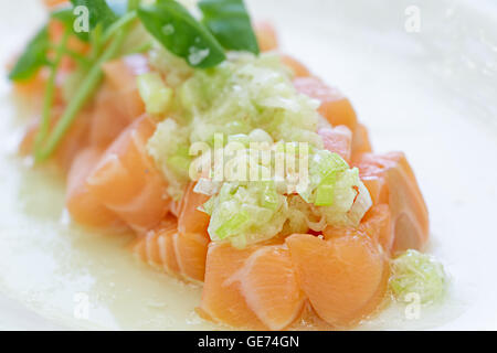 Lachs Poke belegt mit einer grünen Zwiebelsauce Stockfoto