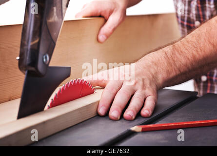 Detail der Tisch sah Klinge und menschliche Hand in gefährliche position Stockfoto