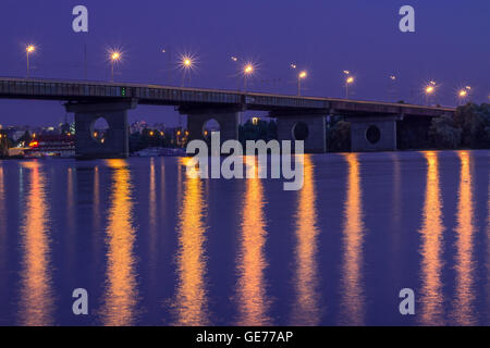 Nachtlichter Brücke spiegelt sich im Wasser des Flusses. HDR Stockfoto