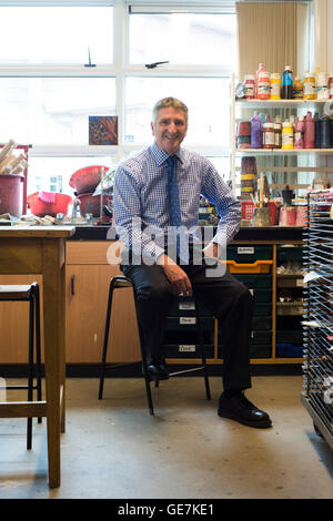 Schulleiter sitzt im Klassenzimmer an ihrer Schule für ein förmliches gestellten redaktionellen Porträt Stockfoto