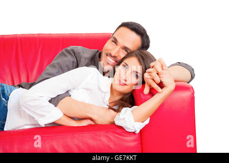 Porträt von romantisch zu zweit auf dem Sofa entspannen. Glücklich liebende männliche und weibliche Partner halten Hände. Sie sind Freizeit verbringen. Stockfoto