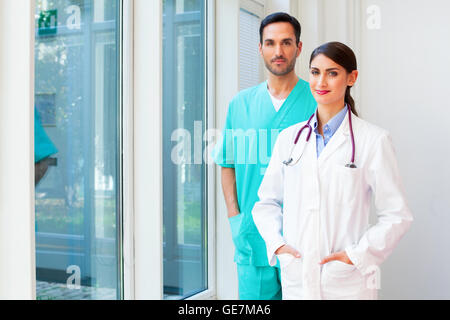 Porträt von zuversichtlich Ärztin mit männlichen Arzt. Junge Mediziner sind in Uniformen. Sie stehen in hospita Stockfoto