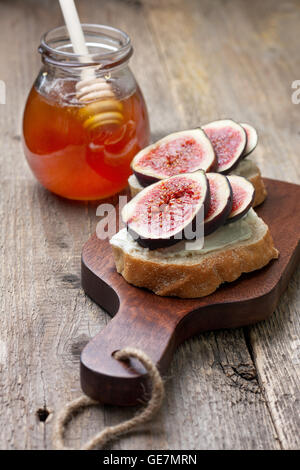 Brot mit Feigen, Ricotta, Honig auf ein Schneidebrett Stockfoto