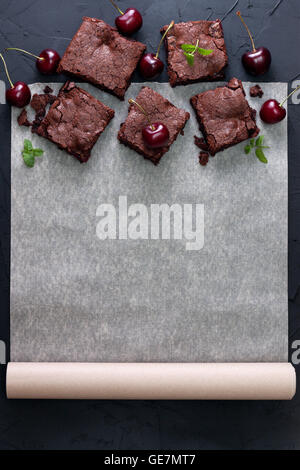 Brownie mit Kirschen auf ein Backpapier mit Platz für Informationen (Draufsicht) Stockfoto