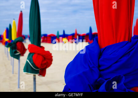 Bunte Sonnenschirme aufgereiht und warten für Sonnenanbeter in Deauville, Frankreich Stockfoto